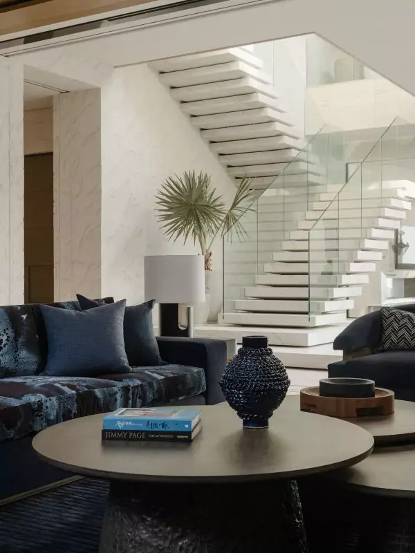 Naga Constructions luxury interior — double-height living room with a sculptural staircase